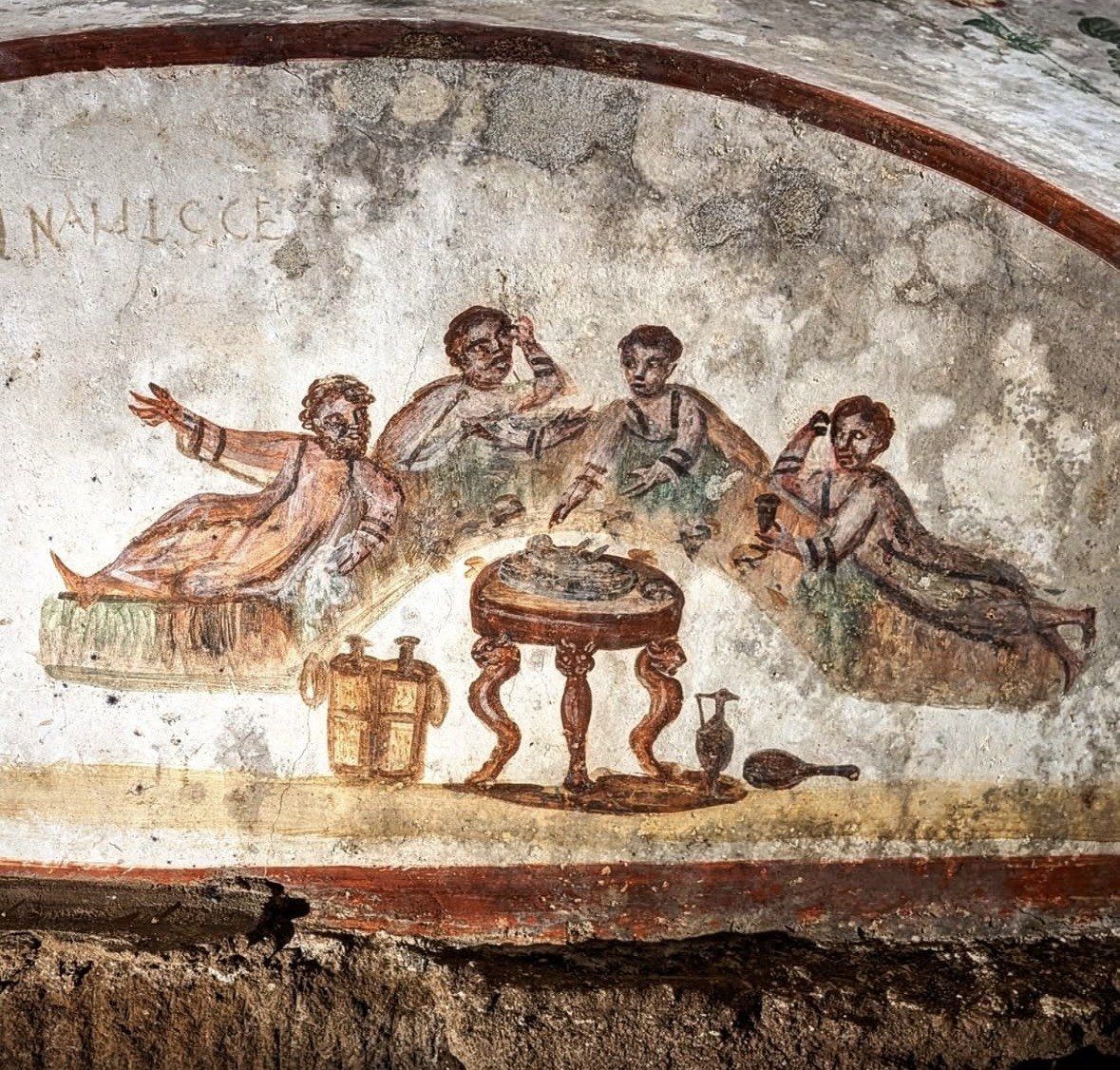 Early Christian fresco of four diners reclining around a round table