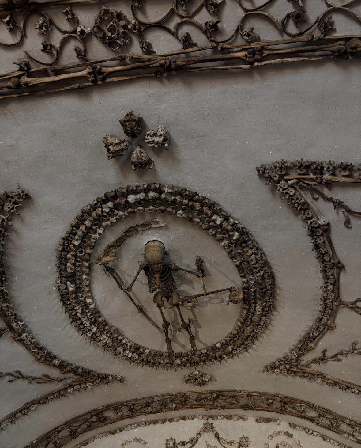 Winged skeleton with scythe and scales inside a vertebrae ring on the ceiling